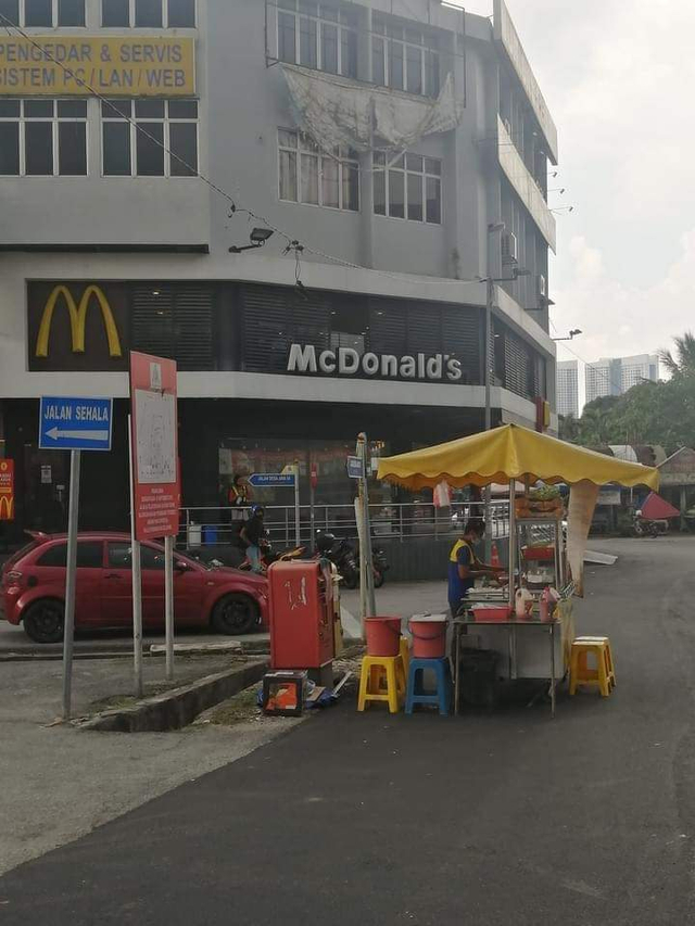 Potret menggelitik penjual burger di Kepong, Malaysia jualan di depan McDonald's. (Foto: Twitter/@craz33sufri).