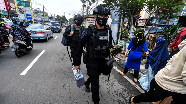 Petugas kepolisian berjalan menuju lokasi penggeledahan salah satu tempat tinggal terduga teroris di kawasan Condet, Jakarta, Senin (29/3/2021). Foto: Muhammad Adimaja/ANTARA FOTO