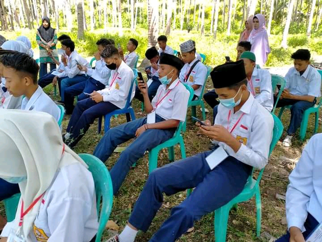 Potret siswa MTs di Baiturrahman, Desa Salimuli, Kecamatan Galela Utara, Halmahera Utara, Maluku Utara, terpaksa ujian di bibir pantai karena sulitnya akses internet di desa tersebut. (Facebook/Julfikar Noho)