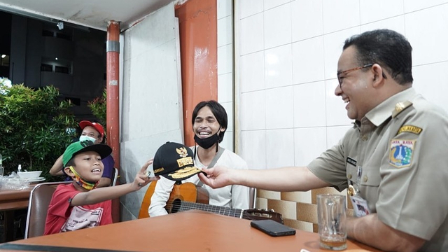 Gubernur DKI Jakarta Anies Baswedan saat mengobrol dengan pengamen ayah-anak di Sate Blora, Rawamangun, Jakarta.
 Foto: Instagram/@aniesbaswedan