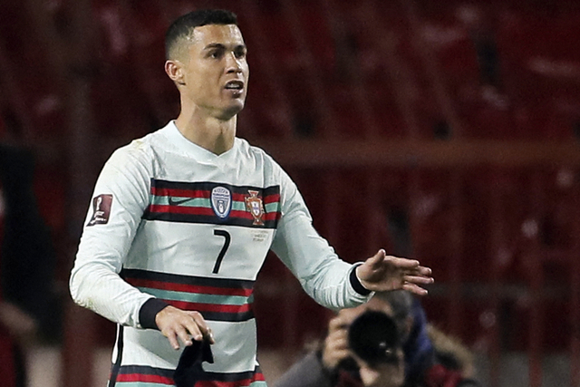 Pemain Portugal Cristiano Ronaldo memegang ban kaptennya di laga Serbia vs Portugal, Minggu (28/3) Foto: Pedja milosavljevic/AFP