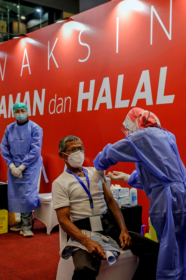 Petugas kesehatan menyuntikkan vaksin corona Sinovac selama program vaksinasi massal di Bursa Efek Indonesia di Jakarta, Rabu (31/3). Foto: Willy Kurniawan/REUTERS