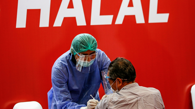 Petugas kesehatan menyuntikkan vaksin corona Sinovac selama program vaksinasi massal di Bursa Efek Indonesia di Jakarta, Rabu (31/3). Foto: Willy Kurniawan/REUTERS