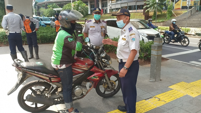 Petugas tindak motor yang parkir liar di seberang Kuningan City Mall.  Foto: Dok. Istimewa