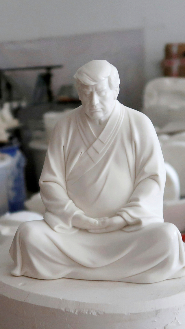 Patung mantan Presiden AS Donald Trump dalam pose meditasi Buddha, yang dibuat di sebuah bengkel di Dehua, provinsi Fujian, China. Foto: Martin Pollard/REUTERS