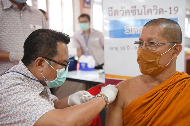 Tim medis menyuntikkan vaksin virus corona Sinovac untuk Biksu Buddha di sebuah kuil di Bangkok, Thailand. Foto: Chalinee Thirasupa/Reuters
