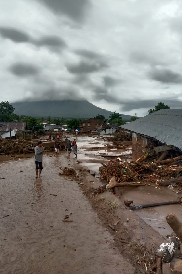 Sejumlah warga menyaksikan rumah yang rusak akibat banjir bandang di Desa Waiburak, Kecamatan Adonara Timur, Flores Timur, NTT, Minggu (4/4).  Foto: BPBD Flores Timur/HO/ANTARA FOTO