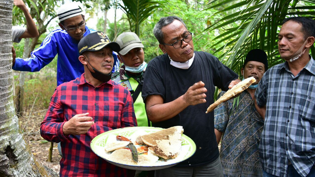 WAKIL Bupati Bengkalis, Bagus Santoso (kiri) saat mendengarkan penjelasan dari pakar lebah madu asal Magaelang, Jawa Tengah, Mbah Hadi Utomo, saat panen madu di Desa Kembung Luar, Bengkalis, Sabtu (3/4/2021).