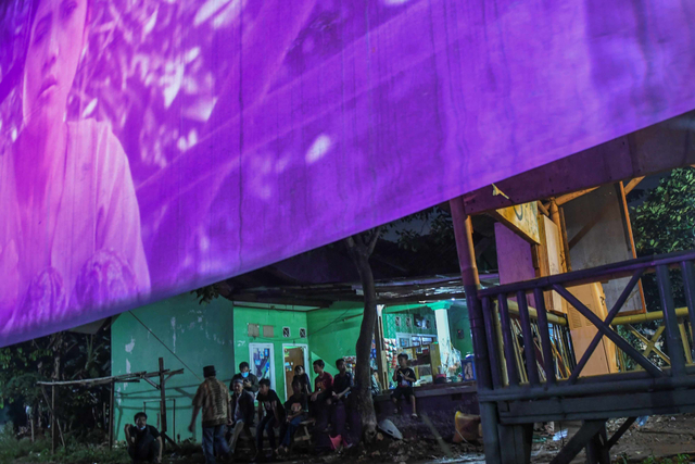 Suasana saat warga menonton layar tancap di kawasan Pondok Aren, Tangerang Selatan, Sabtu (3/4). Foto: Galih Pradipta/Antara Foto