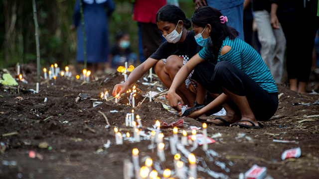 Sejumlah warga menyalakan lilin saat berziarah di tempat pemakaman massal korban tanah longsor di Desa Nelelamadike, Kecamatan Ile Boleng, Kabupaten Flores Timur, Nusa Tenggara Timur (NTT), Rabu (7/4). Foto: Aditya Pradana Putra/ANTARA FOTO