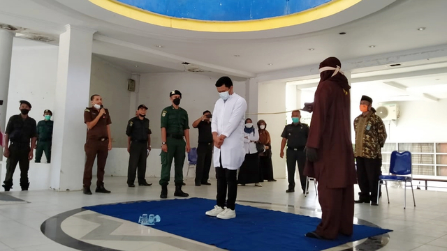 Polisi Syariat Islam atau Wilayatul Hisbah Kota Banda Aceh, melaksanakan eksekusi cambuk terhadap mahasiswa yang kedapatan menjual miras secara sembunyi-sembunyi. Foto: Zuhri Noviandi/kumparan