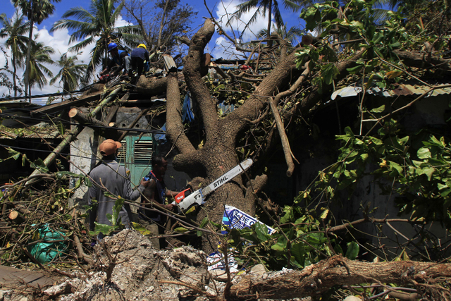 Sejumlah petugas memotong pohon yang tumbang menimpa salah satu rumah karena diterjang gelombang kencang akibat badai Siklon tropis Seroja di Kota Kupang. Foto: Kornelis Kaha/Antara Foto