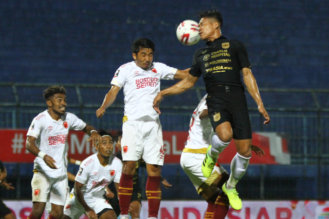 Pemain PSM Makassar M. Arfan (kiri) berebut bola dengan pemain PSIS Semarang Fandi Eko Utomo pada pertandingan perempatfinal Piala Menpora di Stadion Kanjuruhan, Malang, Jawa Timur, Jumat (9/4).  Foto: Ari Bowo Sucipto/ANTARA FOTO