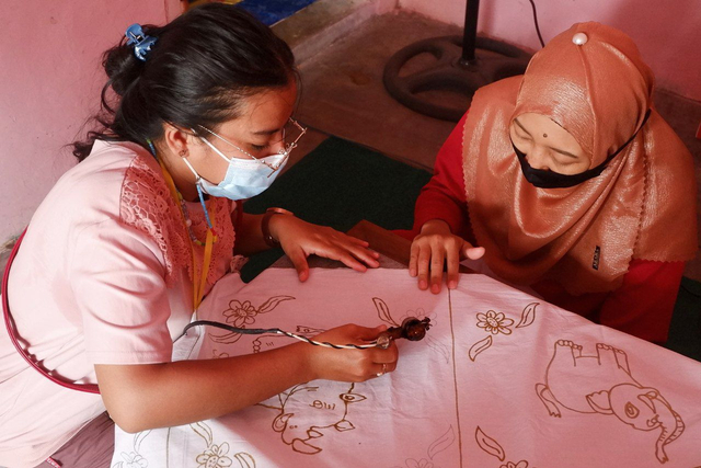 Seorang wanita saat mencoba melukis batik di sanggar batik tulis Barata Desa Labuhan Ratu VII Lampung Timur, Sabtu (9/4) | Foto : Sidik Aryono/ Lampung Geh