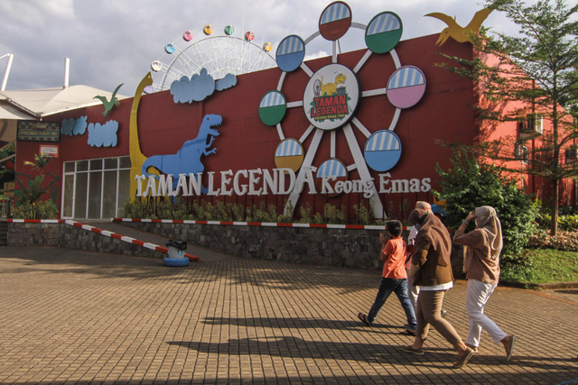 Pengunjung berjalan di depan taman legenda di TMII, Jakarta, Rabu (7/4). Foto: Asprilla Dwi Adha/Antara Foto