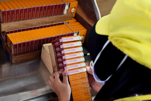 Buruh linting rokok menempel pita cukai di salah satu pabrik rokok di Blitar, Jawa Timur, Kamis (25/3/2021). Foto: Irfan Anshori/Antara Foto