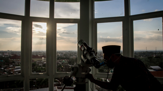 Petugas pemantau hilal melihat matahari terbenam menggunakan teleskop saat kegiatan Pemantauan Hilal di Laboratorium Astronomi dan Ilmu Falak MAN I Solo, Jawa Tengah, Senin (12/4). Foto: Mohammad Ayudha/ANTARA FOTO