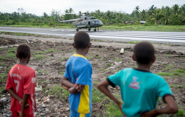 Anak-anak menonton helikopter militer Indonesia Mi17 di bandara Erwer di Agats, kabupaten Asmat, di Papua. Foto: Bay Ismoyo/AFP