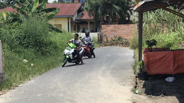 DUA pengendara motor terpaksa memutar balik saat jalan aspal selama ini mereka lalui sudah ditembok dengan batu bata oleh pemilik tanah di Jalan Lampu Merah, Marpoyan Damai, Pekanbaru, Kamis (15/4/2021). 