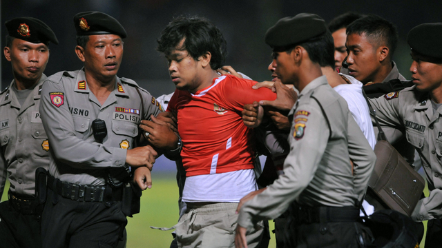 Hendri Mulyadi ditangkap polisi karena nekat masuk lapangan saat Indonesia dikalahkan Oman 1-2 pada partai Pra-Piala Asia 2011 di SUGBK. Foto: Bay Ismoyo/AFP