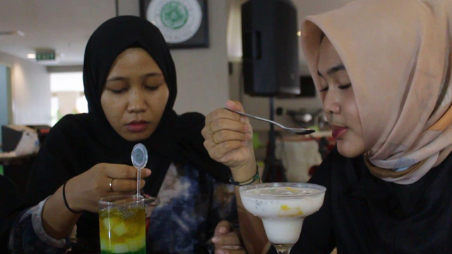 DUA perempuan sedang menikmati minuman Es Laksmana Mengamuk. (Foto: SELASAR RIAU/RAMADHI DWI PUTRA) 