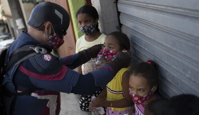 Polisi militer yang mengenakan kostum Captain America yang membagikan masker di Brasil. Foto: AP Photo/Silvia Izquierdo