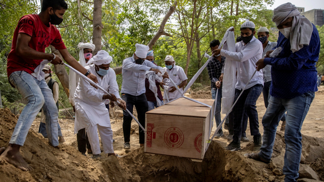 Orang-orang menguburkan jenazah COVID-19 di pemakaman di New Delhi, India, Jumat (16/4). Foto: Danish Siddiqui/REUTERS