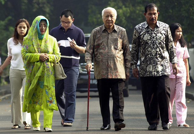Mantan presiden Indonesia Soeharto (tengah) berjalan bersama putrinya Siti Hardiyanti Rukmana "Tutut", dan anggota keluarga lainnya dalam perjalanan ke tempat pemungutan suara di Jakarta, 05 April 2004. Foto: Arif Ariadi/AFP