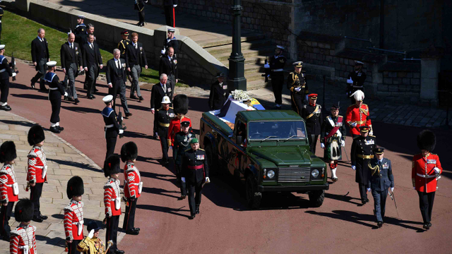 Anggota Keluarga Kerajaan berjalan di belakang mobil jenazah, sebuah Land Rover yang dimodifikasi khusus, di halaman Kastil Windsor selama pemakaman Pangeran Philip. Foto: Pool via REUTERS