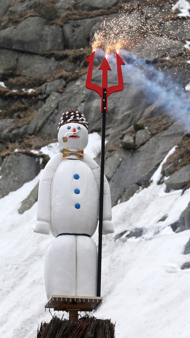 Boeoegg, manusia salju yang berisi petasan, berdiri di atas api unggun di landmark Jembatan Setan di Ngarai Schoellenen, di Andermatt, Swiss, Senin (19/4). Foto: Arnd Wiegmann/REUTERS