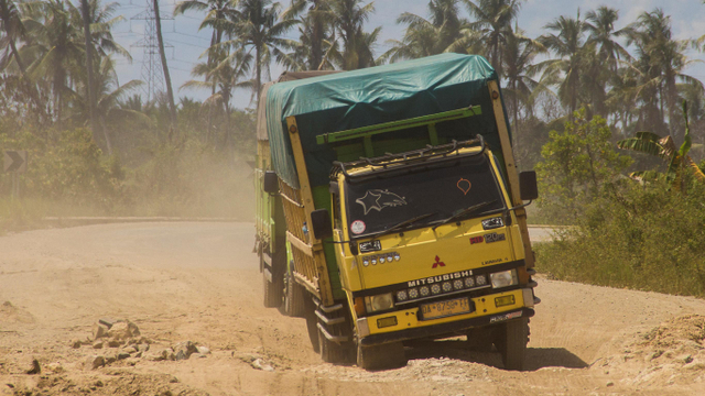 Truk melintas di Jalan Gubernur Syarkawi yang rusak di Kabupaten Banjar, Kalimantan Selatan, Selasa (20/4/2021). Foto: Bayu Pratama S/Antara Foto
