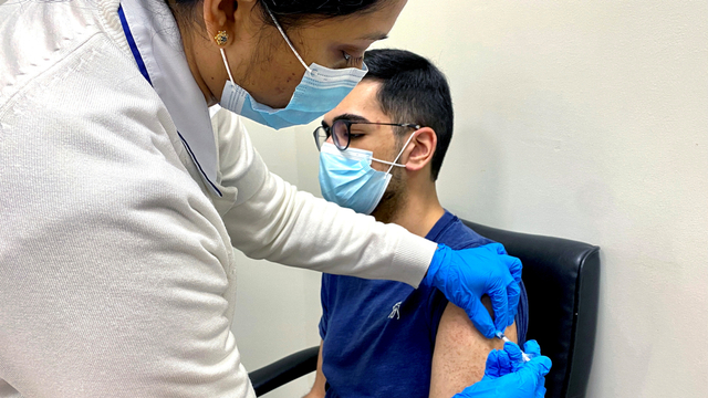 Seorang pria menerima satu dosis vaksin corona di Dubai, Uni Emirat Arab. Foto: Abdel Hadi Ramahi/Reuters