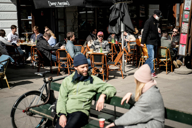 Masyarakat menikmati layanan luar ruangan di kafe, restoran, dan bar yang dibuka kembali di Kopenhagen, Denmark. Foto: Ritzau Scanpix / Mads Claus Rasmussen via Reuters