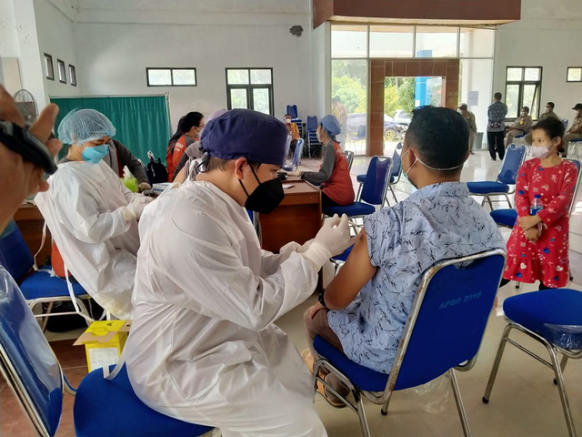 Salah satu tenaga pendidik yang menerima vaksin tahap pertama di Aula Dikbud Kobar. Foto: Fiyya/InfoPBUN.