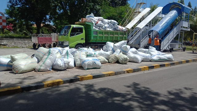 Logistik bantuan dipindahkan dari pesawat Hercules ke truk yang akan mengangkut di Bandara Frans Seda Maumere. Foto: Mario WP Sina.