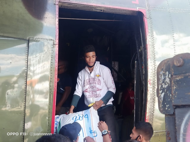 Anggota Tarung Drajat Sikka saat membantu memindahkan bantuan dari pesawat Hercules ke truk pengangkut di Bandara Frans Seda Maumere. Foto: istimewa.