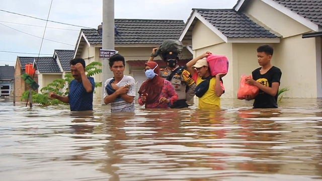 APARAT Kepolisian membantu warga Perumahan Pesona Harapan Indah, Pekanbaru, yang terendam banjir setinggi 1,5 meter, Kamis (22/4/2021).  