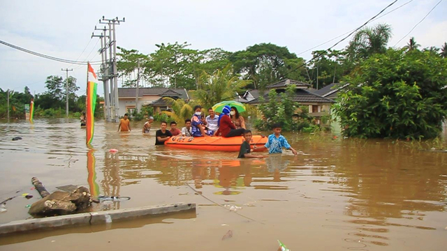 MENGGUNAKAN perahu karet warga evakuasi dari rumah mereka yang terendam banjir. 
