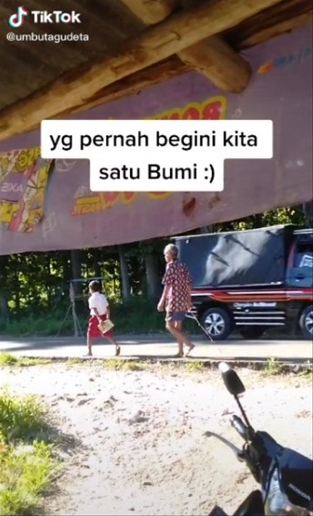 Viral video seorang ayah Kabupaten Sumba Barat Daya, Kecamatan Kodi, Pulau Sumba, NTT antar anak ke sekolah sambil memegang ranting pohon. (Foto: TikTok/@umbutagudeta)