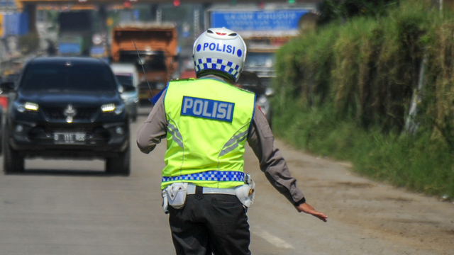 Petugas gabungan memberhentikan kendaraan untuk memeriksa kelengkapan surat dari pengendara dengan kendaraan nomor polisi luar Bandung di gerbang keluar Tol Cileunyi. Foto: Raisan Al Farisi/Antara Foto