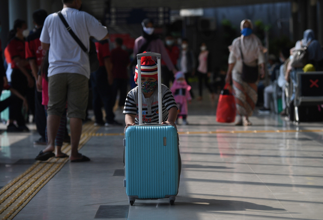 Seorang anak mendorong koper di ruang tunggu Stasiun Pasar Senen, Jakarta, Minggu (25/4). Foto: Akbar Nugroho Gumay/Antara Foto