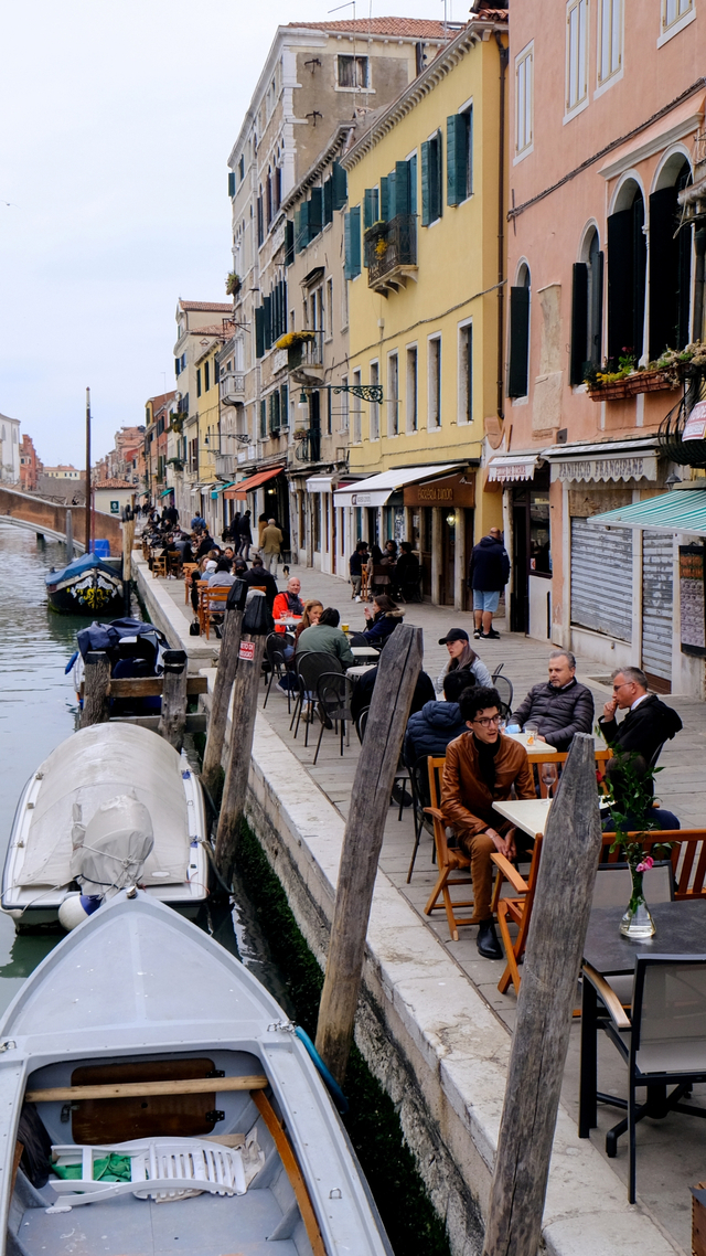 Sejumlah orang menikmati minuman malam aperitivo sambil duduk di bar luar ruangan, di Venesia, Italia, Senin (26/4). Foto: Manuel Silvestri/REUTERS