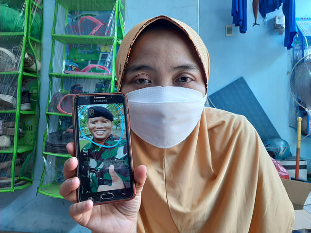 Dian Arisa, menunjukkan foto sang suami Serda Kom Purwanto. Foto-foto: Amanah Nur Asiah/Basra