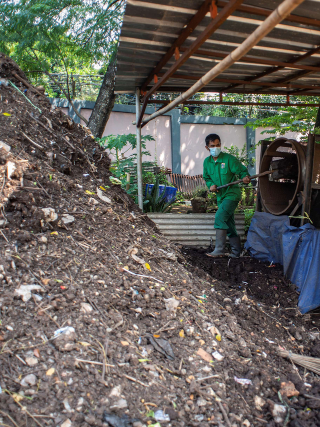 Pekerja melakukan penyaringan pupuk kompos di halaman Gedung Pengolahan Sampah, kompleks Taman Margasatwa Ragunan, Jakarta, Selasa (27/4). Foto: Aprillio Akbar/Antara Foto