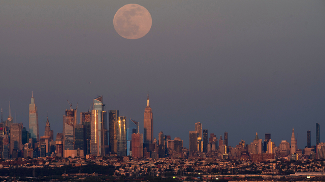 Bulan purnama muncul di atas cakrawala New York dan Empire State Building, seperti yang terlihat dari West Orange, di New Jersey, AS, Senin (26/4). Foto: Eduardo Munoz/REUTERS