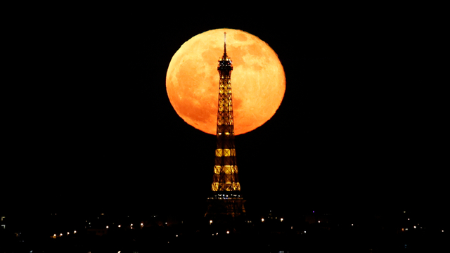 Bulan purnama atau pink super moon muncul di belakang Menara Eiffel di Paris, Prancis, Selasa (27/4). Foto: Christian Hartmann/REUTERS