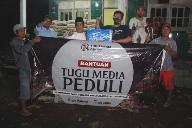 Kades Wirotaman, Ahmad Sholeh, saat menerima bantuan dari Tugu Media Group. (Foto: Rubianto)