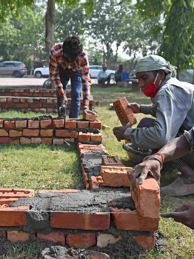 Para pekerja terlihat membangun platform darurat untuk tumpukan kayu pemakaman di krematorium di New Delhi, India, Selasa (27/4). Foto: Sajjad Hussain/AFP