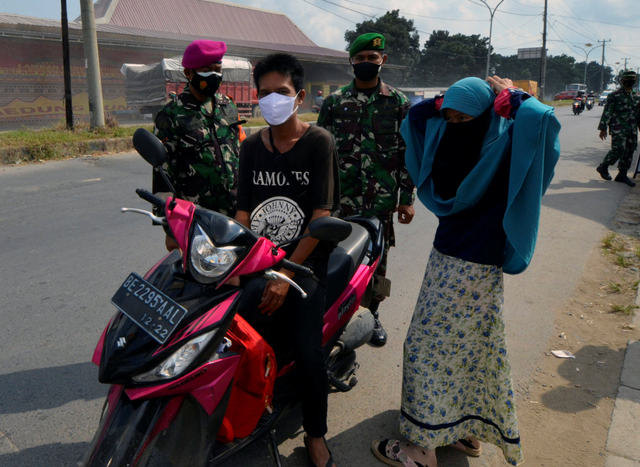 Petugas gabungan Satgas COVID-19 Kota Bandar Lampung memberhentikan pengendara motor yang tidak mengenakan masker saat berkendara di Kota Bandar Lampung, Lampung. Foto: Ardiansyah/Antara Foto