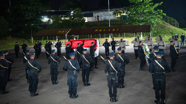 Personel Brimob Polda Sumatera Selatan mengusung peti jenazah I Komang Wira Natha tiba di Bandara Internasional Sultan Mahmud Badaruddin (SMB) II Palembang, Sumatera Selatan (28/4/2021). Foto: Nova Wahyudi/ANTARA FOTO